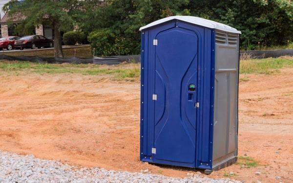 Portable restrooms lined up for an outdoor festival event