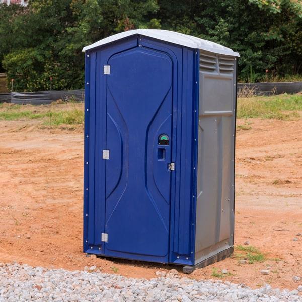 Row of standard green portable toilets set up outdoors for rent in Lorain, Ohio